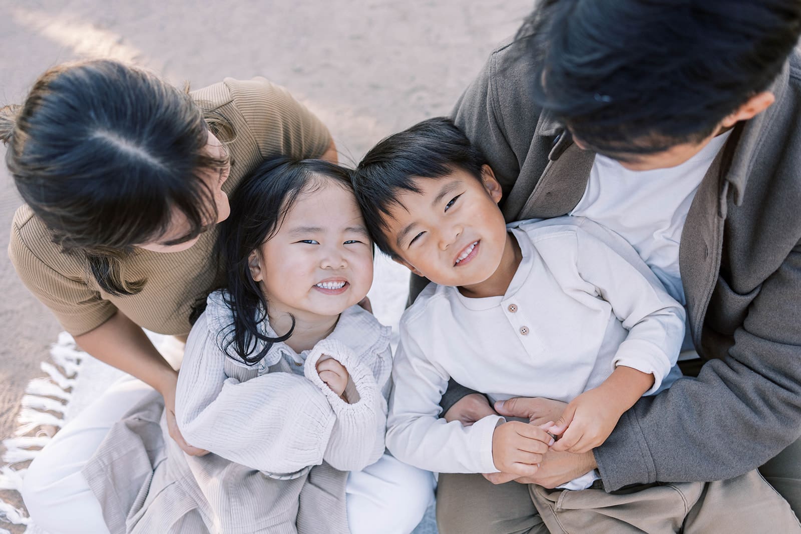 Asian children smiling as their parents hold them in Irvine California