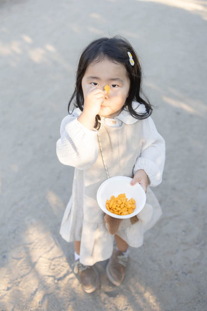 Little girl in a dress eating goldfish crackers in Orange County California