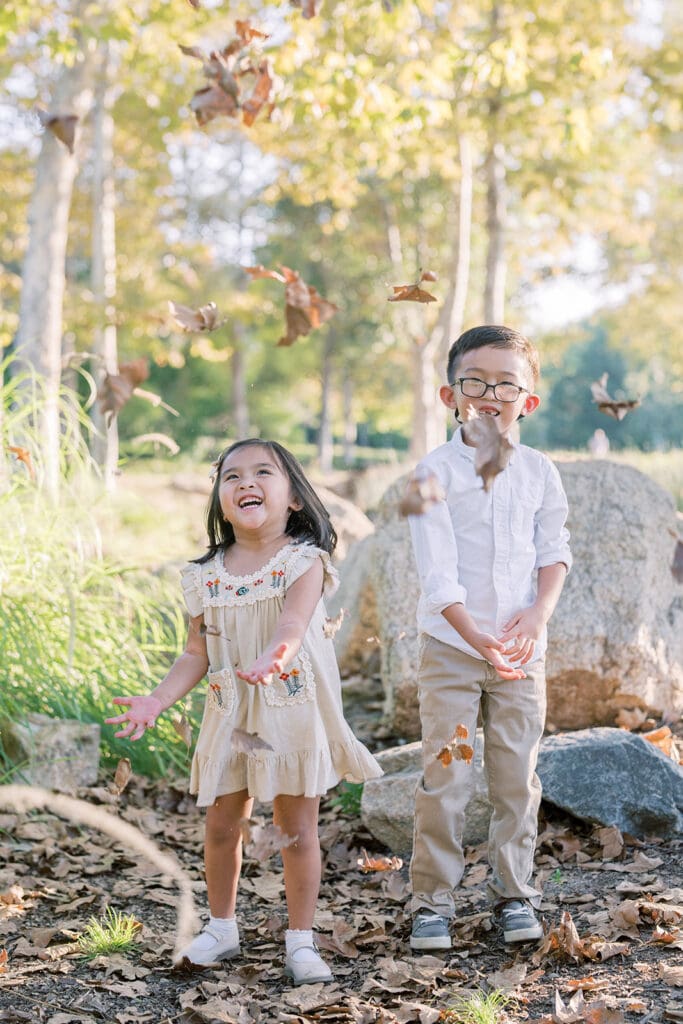 children tossing leaves in the summer